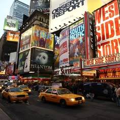 a busy city street filled with lots of traffic and tall buildings covered in billboards