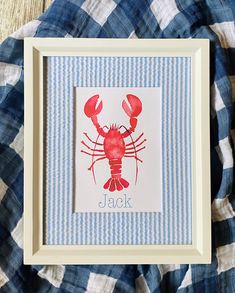 a red lobster in a white frame on a blue and white checkered blanket