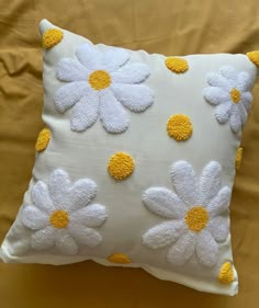 a white pillow with yellow and white flowers on it