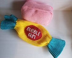 two crocheted hats sitting next to each other on top of a white table