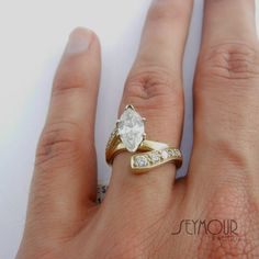 a woman's hand with a gold and white ring on top of her finger