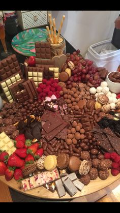 a table topped with lots of different types of chocolates and strawberries on top of it