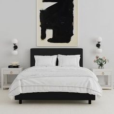 a black and white bedroom with a large painting on the wall