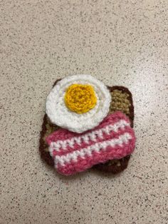 a crocheted object with an egg on top