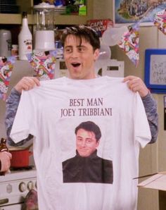 a man holding up a t - shirt that says best man, joey tribbiani