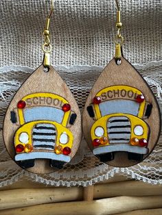 two wooden earrings with school buses painted on them