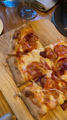 two slices of pizza sitting on top of a wooden cutting board