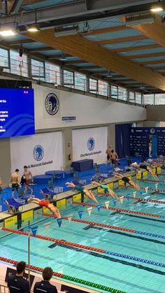 an indoor swimming pool filled with swimmers