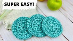 two crocheted scrub pads sitting on top of a white table next to apples