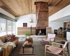 a living room filled with furniture and a fire place in the middle of a room