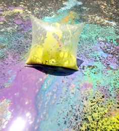 a yellow pillow sitting on top of a table covered in paint and sprinkles