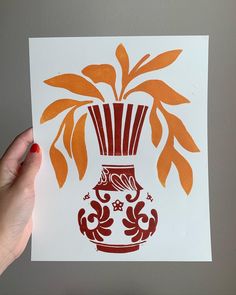 a hand holding up a card with an orange vase on it