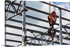 a crane is hanging from the side of a building with metal bars on it's sides