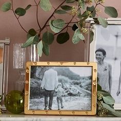 an old photo is sitting on a mantle next to some plants and other things in front of it