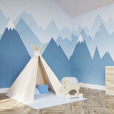 a child's room with mountains painted on the wall and a teepee tent