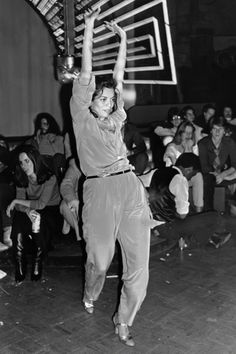 an old photo of a man holding up a basketball hoop in front of a crowd