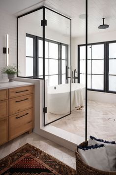 a bathroom with a tub, sink and large mirror