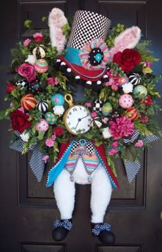 a stuffed animal wearing a top hat and holding a clock in front of a door