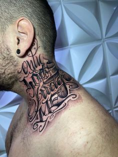 a man with a tattoo on his neck and behind the ear has words written all over it