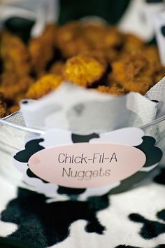 a bowl filled with fried food on top of a cow print tablecloth covered table