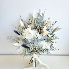 a bouquet of white and blue flowers on a table