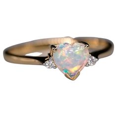 an opal and diamond ring on a white background