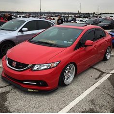 a red car parked in a parking lot next to other cars