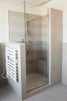 a walk in shower sitting inside of a bathroom next to a wall mounted heater