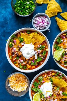 three bowls of mexican soup with tortilla chips and sour cream on the side