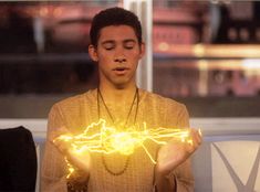 a young man is holding out his hands with glowing lights