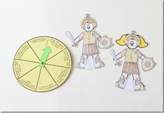 two paper dolls next to a clock on a white surface with words cut out from it