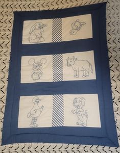 a blue and white quilt with pictures of animals on it