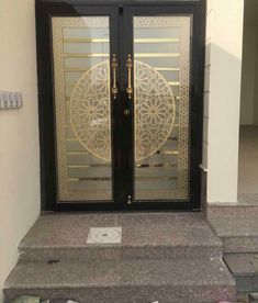 the front door to a house that has been decorated with gold and black glass doors