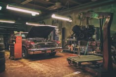 an old car is being worked on in a garage