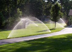 two sprinklers are spraying water on the grass