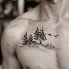 a man's chest with trees and birds tattoo on his left side ribcage