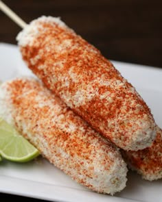 two corn on the cob with lime wedges