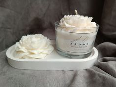 a white candle sitting on top of a glass container