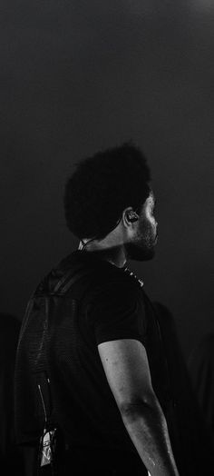 a black and white photo of a man with an afro on his head looking off into the distance