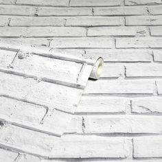 a roll of tape sitting on top of a white brick wall