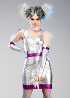 a woman dressed in silver and purple is posing