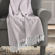 a chair with a blanket on top of it and a rug in front of it