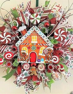 a christmas wreath decorated with candy canes, candies and a gingerbread house