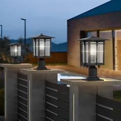 three lights on top of a fence near a house