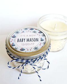 a small jar with a baby mason label on it next to a larger jar filled with candles