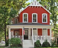 a red and white house with a flag on the front porch