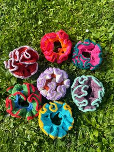 six crocheted donuts laying in the grass