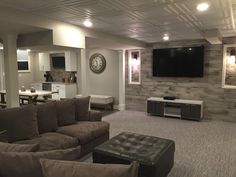 a living room filled with furniture and a flat screen tv mounted to the wall over a fireplace