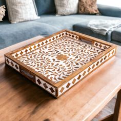 a wooden tray sitting on top of a table next to a blue couch in a living room