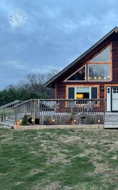 a large wooden house sitting on top of a lush green field